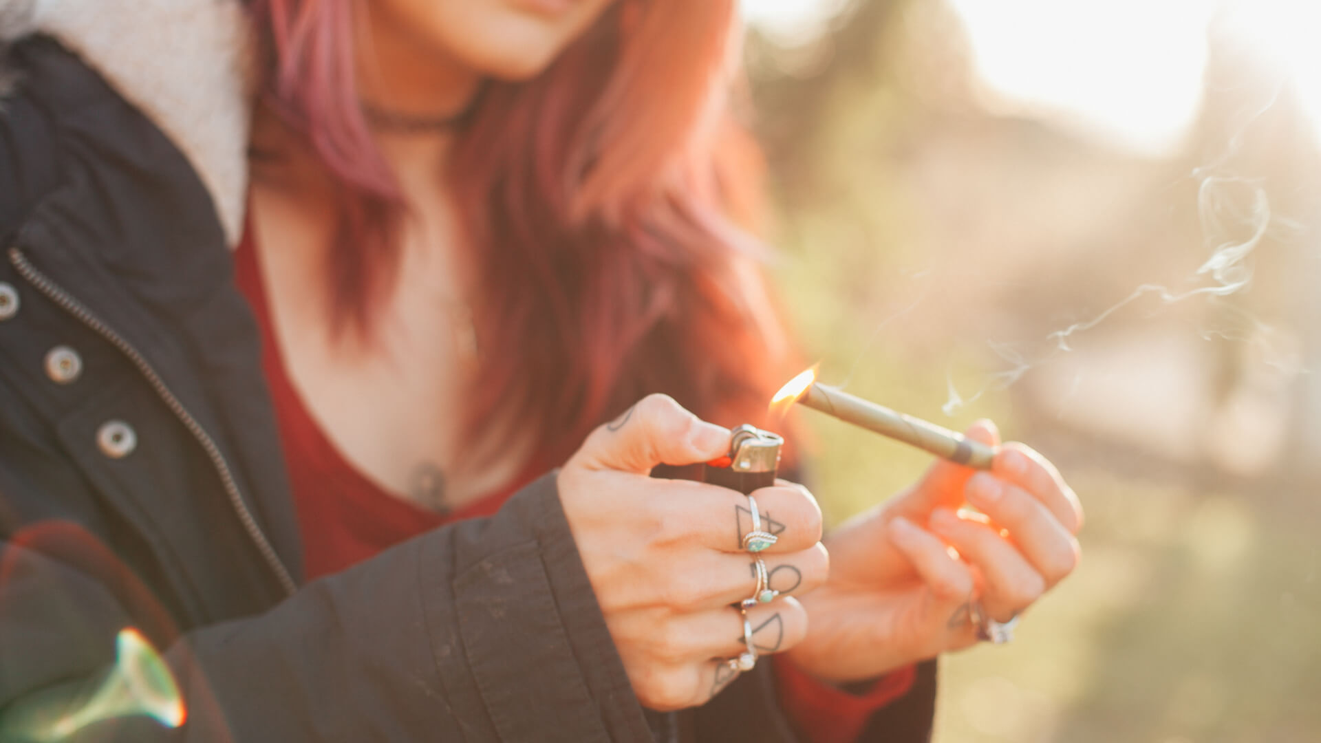 A woman lighting a joint